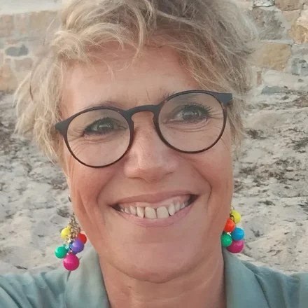 Karine Baridon, autrice del romanzo L'amaca e i colibrì, sorride su una spiaggia
